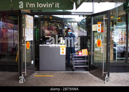 Lviv, Ukraine - 17 mai 2020 : restaurant McDonalds, femme de service préparant une commande de nourriture pour la cueillette sans aucun effort. Santé et distance sociale con Banque D'Images