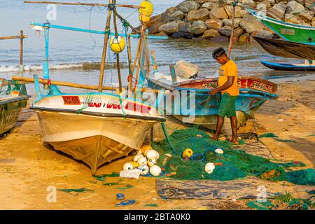 Les pêcheurs ont tendance à se rendre à leurs filets par leurs bateaux sur la plage à l'extérieur de Galle Banque D'Images