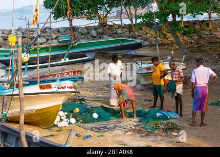 Les pêcheurs ont tendance à se rendre à leurs filets par leurs bateaux sur la plage à l'extérieur de Galle Banque D'Images