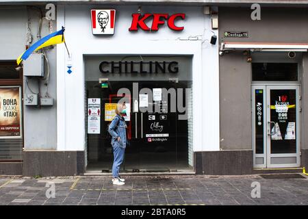 Lviv, Ukraine - 17 mai 2020 : KFC à Lviv, femme en attente de la cueillette de la commande alimentaire sans aucun contrôle. Concept de soins de santé et de distance sociale. Sélectif f Banque D'Images