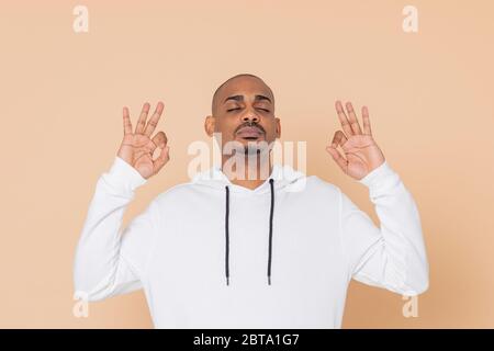 Un homme africain avec un sweat-shirt blanc sur fond jaune Banque D'Images