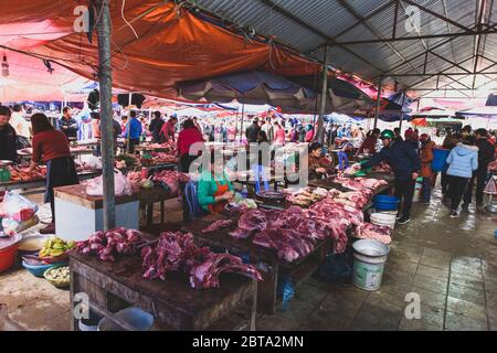 Bac Ha, Vietnam, 7 janvier 2020 - Boucher à bac Ha Market saling la viande crue sur sa table noire en bois Banque D'Images