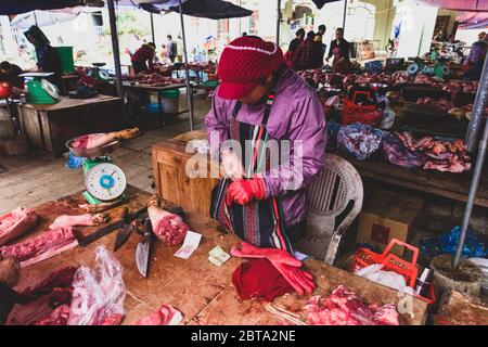 Bac Ha, Vietnam, 7 janvier 2020 - Boucher à bac Ha Market saling la viande crue sur sa table noire en bois Banque D'Images