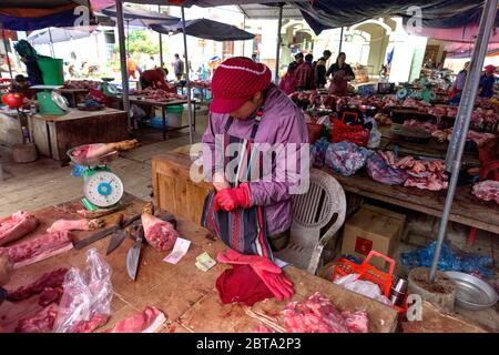 Bac Ha, Vietnam, 7 janvier 2020 - Boucher à bac Ha Market saling la viande crue sur sa table noire en bois Banque D'Images