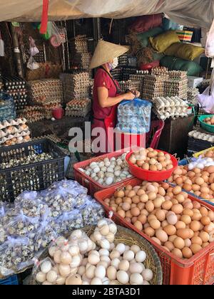 Hue, Vietnam, 20 janvier 2020 - dame méconnaissable au milieu d'un assortiment d'oeufs en vrac de la ferme sur un marché, court-circuit produit Banque D'Images