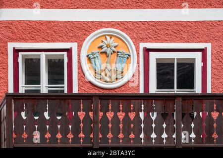 Vue sur la façade d'une maison traditionnelle avec le relief illustré des fleurs alpines gentiane et edelweiss - Hallstatt, Salzkammergut, Autriche Banque D'Images