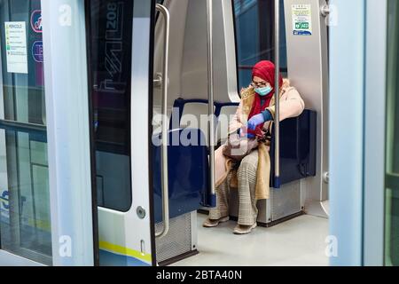 Turin, Italie - 10 mars 2020 : une femme portant un masque respiratoire regarde son mobile lorsqu'elle monte dans un métro. Le gouvernement italien enferme tout le pays alors que l'Italie lutte contre la deuxième épidémie de coronavirus COVID-19 la plus meurtrière au monde après la Chine. Crédit: Nicolò Campo/Alay Live News Banque D'Images