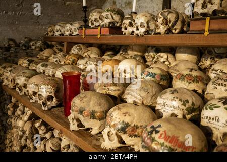 Vue sur des centaines de crânes et d'os peints à l'intérieur de la célèbre maison de charnel au village de montagne Hallstatt dans la région de Salzkammergut, en Autriche Banque D'Images