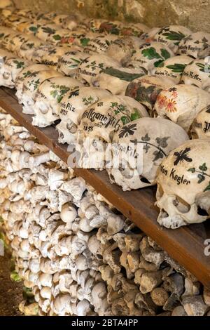 Vue sur des centaines de crânes et d'os peints à l'intérieur de la célèbre maison de charnel au village de montagne Hallstatt dans la région de Salzkammergut, en Autriche Banque D'Images