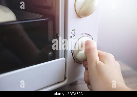 Gros plan sur le réglage manuel de la minuterie du four à micro-ondes. Concept de cuisine maison ou de préparation de nourriture Banque D'Images