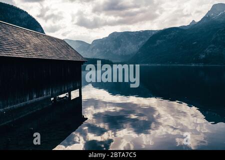 Une serre en bois au bord du lac Hallstatt, dans la région du Salzkammergut, à OÖ, en Autriche, avec le glacier de Dachstein et le Krippenstein en arrière-plan Banque D'Images