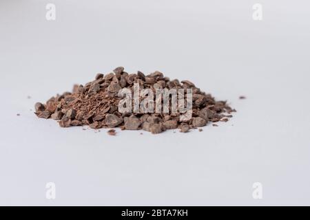 Granules de chocolat utilisés pour faire du chocolat chaud sur fond blanc vu en ligne avec la surface Banque D'Images