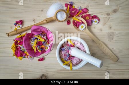 Sel floral maison, pelez dans un mortier avec pétales de fleurs comestibles de jardin, saveur et couleurs de roses et de fleurs diverses, vue du dessus Banque D'Images