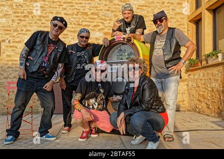 CHARNAY, FRANCE, 5 juillet 2019 : un groupe de rock amateur pose avec une boîte de juke sur la place principale du village. Banque D'Images