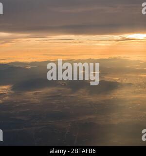 Vue magnifique sur le lever du soleil au-dessus des nuages avec lumière spectaculaire de la fenêtre d'airplace. Banque D'Images