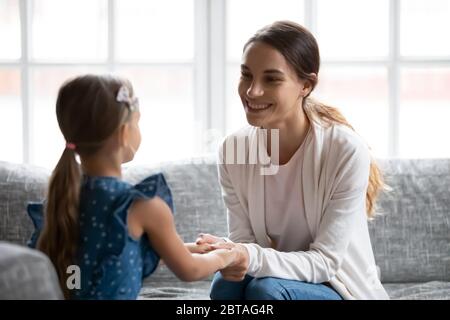 Jeune maman souriante et petite fille se réconcilient après le combat Banque D'Images