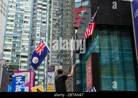 Hong Kong, Chine. 24 mai 2020. Un manifestant porte le drapeau des États-Unis et de la colonie britannique de Hong Kong lors d'un rassemblement anti-gouvernement.Pékin insiste pour mettre en œuvre de nouvelles lois strictes en matière de sécurité nationale et de loi anti-sédition au nom de la ville et contourne le pouvoir législatif de Hong Kong. Crédit : SOPA Images Limited/Alamy Live News Banque D'Images