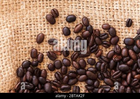 Les grains de café rôtis sont en tissu de sac de jute. Plan à plat, photo d'arrière-plan de la vue de dessus Banque D'Images