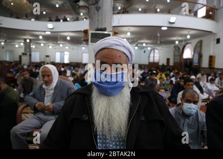 Gaza, Palestine. 24 mai 2020. Un musulman palestinien écoute l'Imam tout en portant un masque facial comme précaution contre le virus corona, pendant Eid Al-Fitr après la réouverture des mosquées par les autorités locales et la détente de certaines restrictions.Eid Al-Fitr marque la fin du Saint mois de jeûne du Ramadan. Crédit : SOPA Images Limited/Alamy Live News Banque D'Images