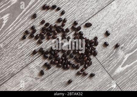 Les grains de café rôtis sont sur un bureau en bois gris, photo avec vue du dessus avec mise au point sélective Banque D'Images