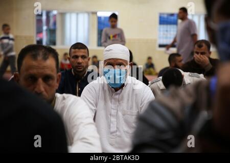 Gaza, Palestine. 24 mai 2020. Un musulman palestinien écoute l'Imam tout en portant un masque facial comme précaution contre le virus corona, pendant Eid Al-Fitr après la réouverture des mosquées par les autorités locales et la détente de certaines restrictions.Eid Al-Fitr marque la fin du Saint mois de jeûne du Ramadan. Crédit : SOPA Images Limited/Alamy Live News Banque D'Images