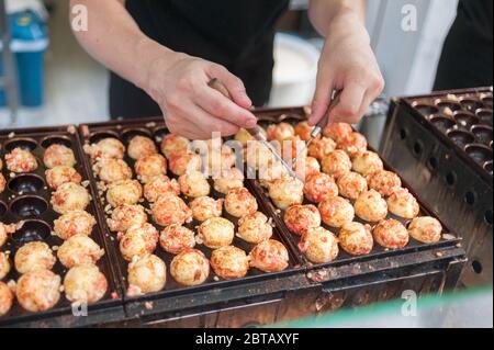 Le takoyaki est une cuisine de rue de la région de Kansai au Japon ; le plat est composé de calmars et c'est une balle grillée que vous pouvez manger directement. Banque D'Images