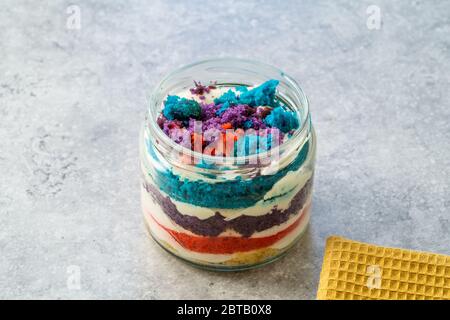 Gâteau arc-en-ciel dessert dans un pot en verre aromatisé aux dragee et aux fruits. Prêt à manger. Banque D'Images