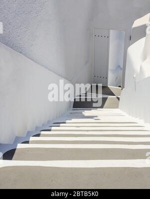 Île de Santorini, Grèce, blanc architecture traditionnelle dans la caldeira, escaliers et détails de bâtiment, marches descendant à une porte ouverte, photo verticale Banque D'Images