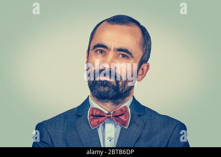 Gros plan portrait jeune homme heureux. Taille basse avec barbe en tenue classique en studio. Modèle barbu de race mixte isolé sur fond vert jaune dégradé Banque D'Images