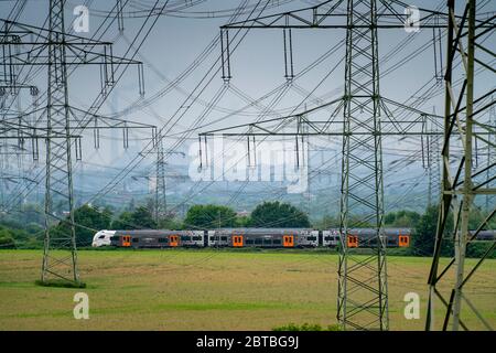 Train sur la ligne entre Essen et Bochum, lignes électriques, réseau électrique extra-haute tension, 380 kilovolts, transporte l'électricité produite dans une grande centrale électrique Banque D'Images