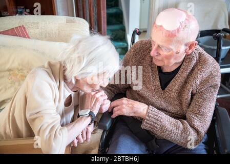 Toujours amoureux dans leurs années 90, ensemble, à la fois vivre et dormir dans le salon en bas en raison de leurs conditions de santé et s'occuper par la famille Banque D'Images