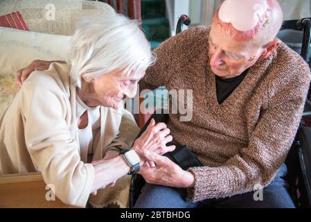 Toujours amoureux dans leurs années 90, ensemble, à la fois vivre et dormir dans le salon en bas en raison de leurs conditions de santé et s'occuper par la famille Banque D'Images