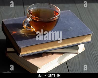 Composition avec une tasse de thé sur de vieux livres. Banque D'Images