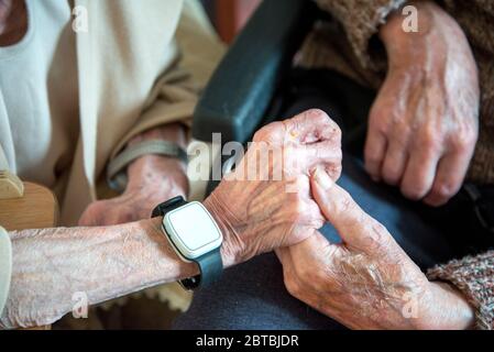 Leurs vieilles mains se rassemblent, toujours amoureux dans leurs années 90, ensemble, vivant et dormant dans le salon en bas en raison de leur mauvaise santé Banque D'Images