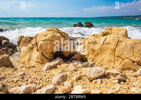 Rochers et vagues sur une plage de galets près de la ville de Novalja sur l'île de Pag en Croatie Banque D'Images