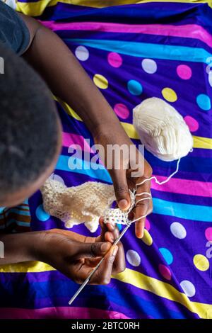 un garçon africain adore tricoter à la maison Banque D'Images