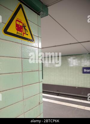 Panneau dans la gare allemande de U-bahn, envoûtant les gens qui font attention quand le train arrive et ne tombent pas dans les voies ferrées Banque D'Images