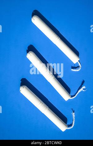 Tampons hygiéniques sur fond bleu et violet. Espace de copie, tampons hygiéniques menstruels pour la protection de l'hygiène des femmes. Jours critiques. Banque D'Images