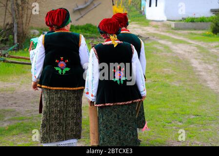 Les femmes âgées vêtues de costumes nationaux ukrainiens, de chemises brodées et de gilets marchent à la fête ethnique dans le paysage rural. Printemps, été Banque D'Images