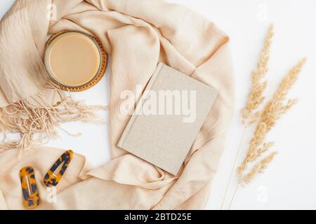 Espace de travail féminin avec couverture beige, fleurs sèches et tasse de café. Table de bureau élégante. Flat lay, vue de dessus. Style hygge ou bohème autu Banque D'Images