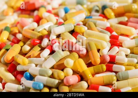 Des dizaines de pilules ou capsules pharmaceutiques colorées en gros plan dans une texture de fond plein cadre pour les concepts médicaux et de soins de santé Banque D'Images