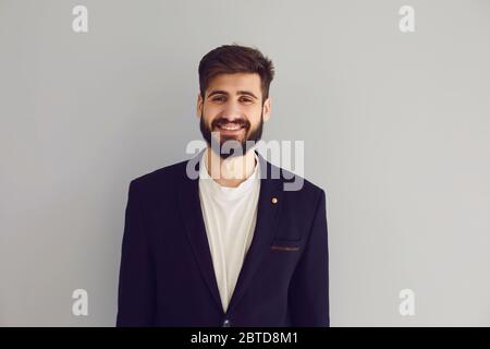 Homme d'affaires ethnique joyeux regardant la caméra sur fond gris Banque D'Images