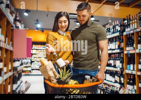 Couple choisissant le vin dans le supermarché d'épicerie Banque D'Images