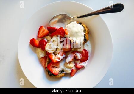 Petit-déjeuner : fraises, banane, yaourt et muffin aux myrtilles Banque D'Images
