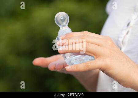 Une vraie jeune femme nettoie ses mains avec du gel hydroalcoolique comme méthode de prévention pour éviter de répandre COVID-19 à d'autres personnes à Madrid. Banque D'Images