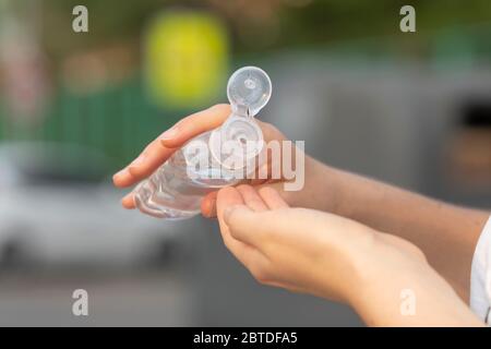 Une vraie jeune femme nettoie ses mains avec du gel hydroalcoolique comme méthode de prévention pour éviter de répandre COVID-19 à d'autres personnes à Madrid. Banque D'Images