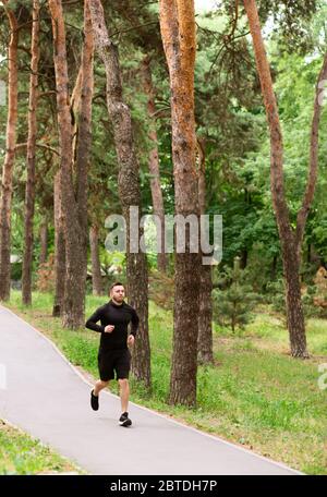 Homme coureur jogging sur la route, exercice en extérieur Banque D'Images