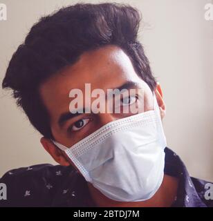 Jeune homme dans masque facial protecteur . homme faisant des mouvements attirants du visage. Banque D'Images