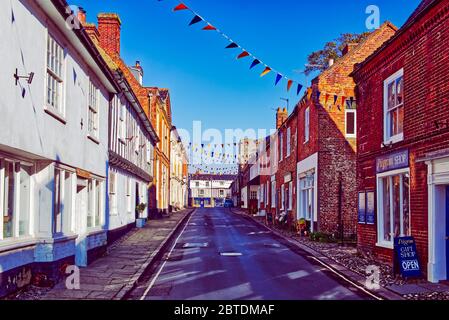 Bunting décore la High Street de la destination de pèlerinage de Little Walsingham, Norfolk, Royaume-Uni. Banque D'Images