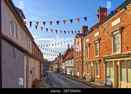 Bunting décore la High Street de la destination de pèlerinage de Little Walsingham, Norfolk, Royaume-Uni. Banque D'Images